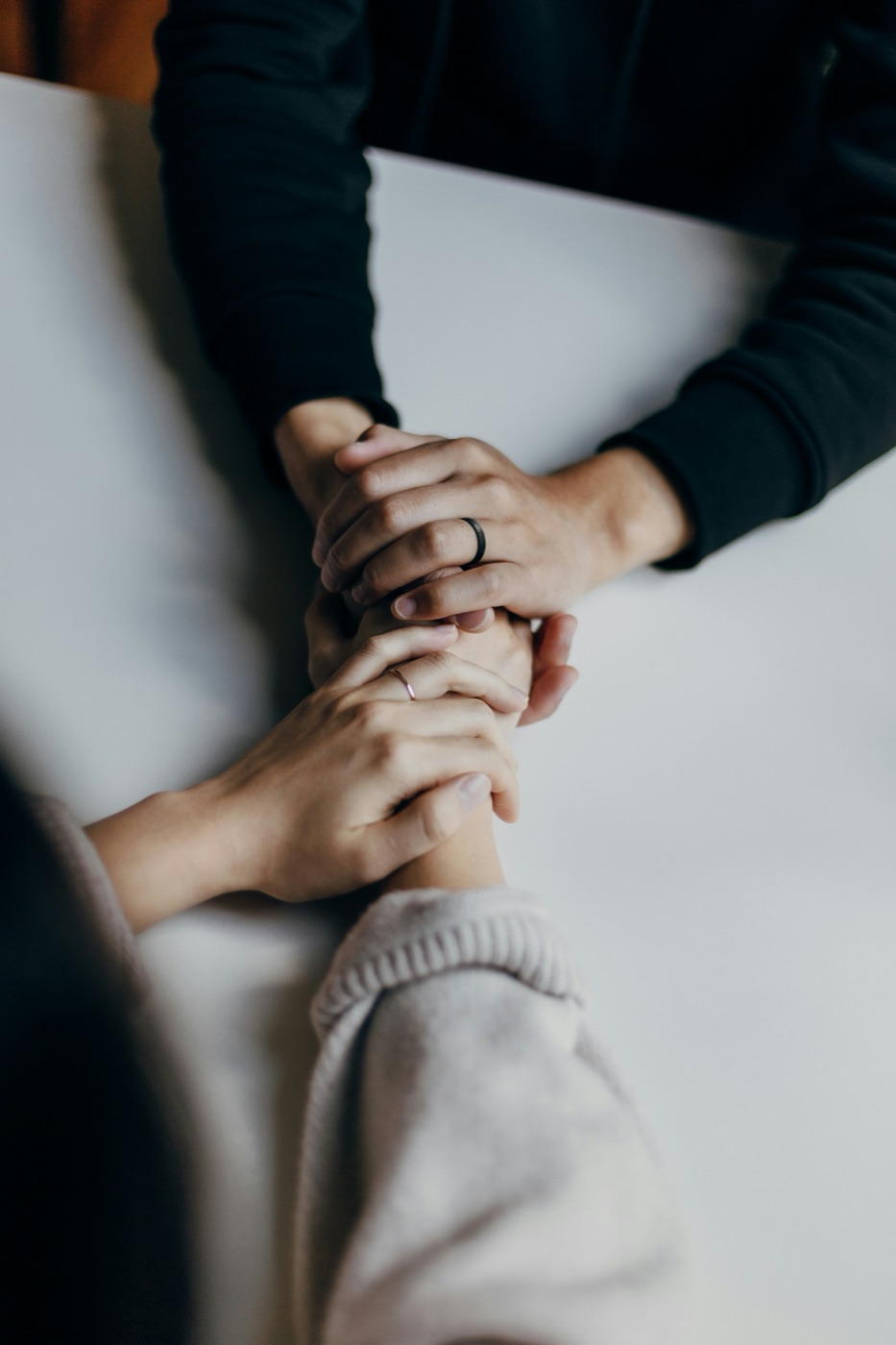 Two people holding hands in support